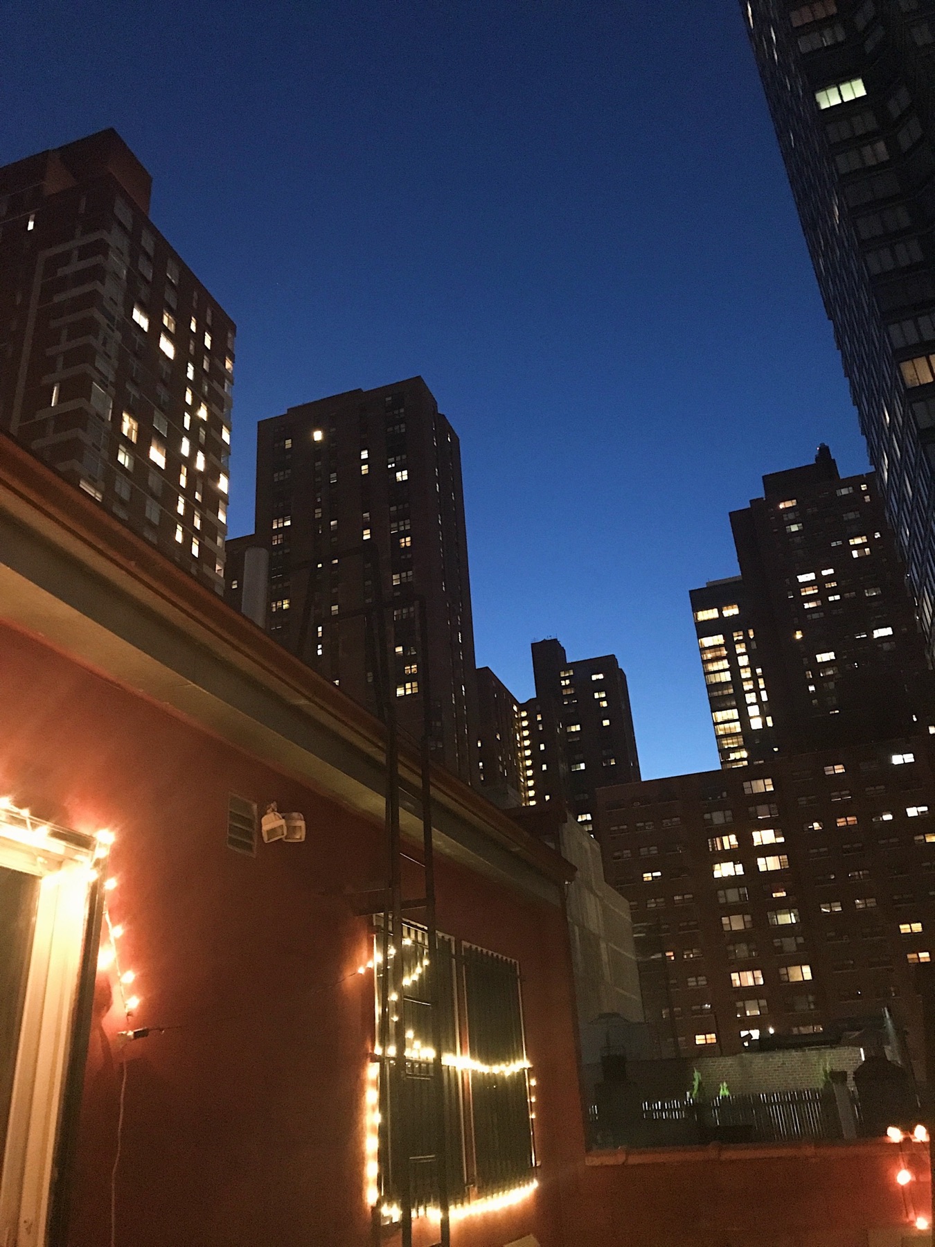 New York City buildings against a deep blue evening sky